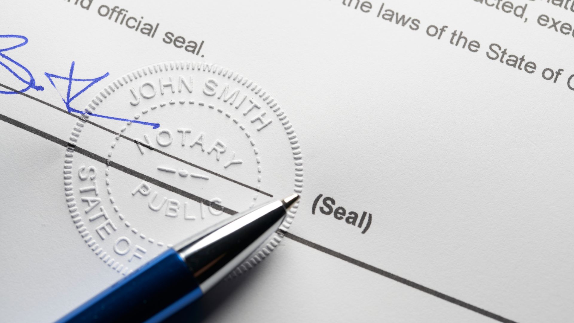 Notary seal and blue pen on official document with signature line