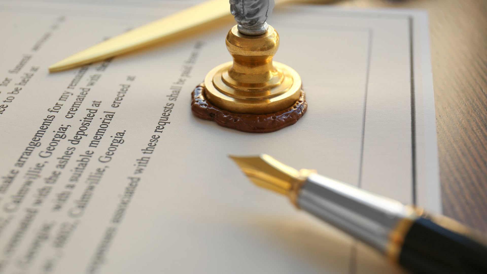 Golden notary seal and fountain pen on official document close-up