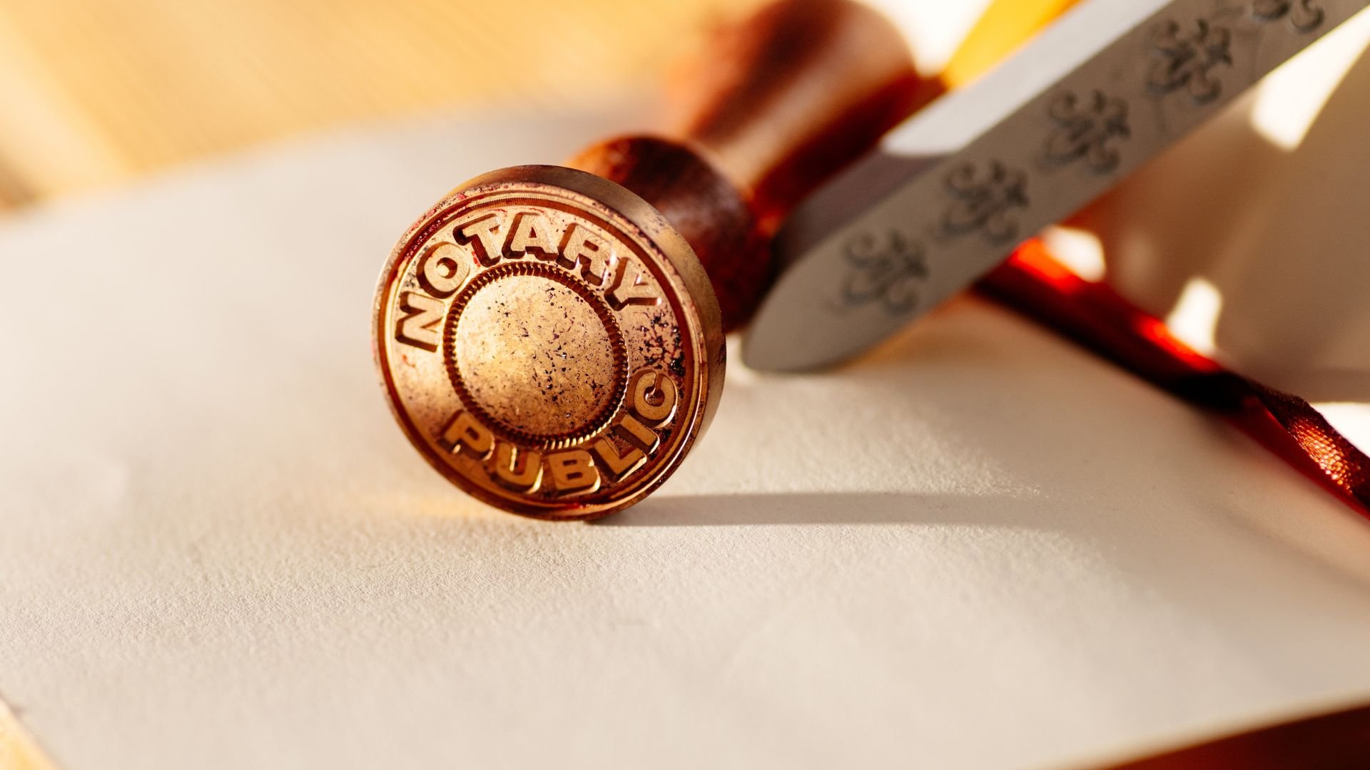 Notary public seal stamp on a document with warm lighting