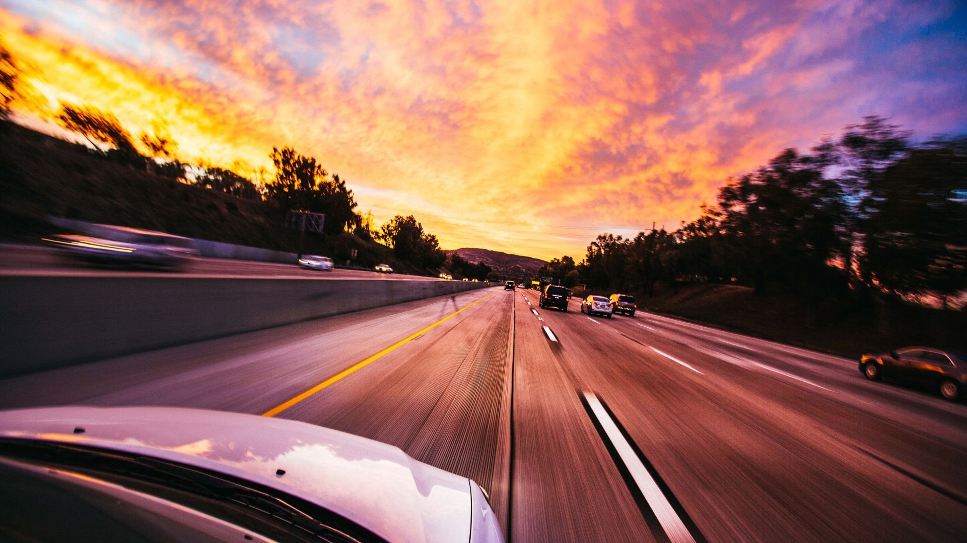 Highway driving at sunset with colorful sky and motion blur